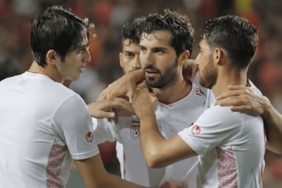 Supporters iraniens animant le stade avec des drapeaux lors d'un match de qualification.
