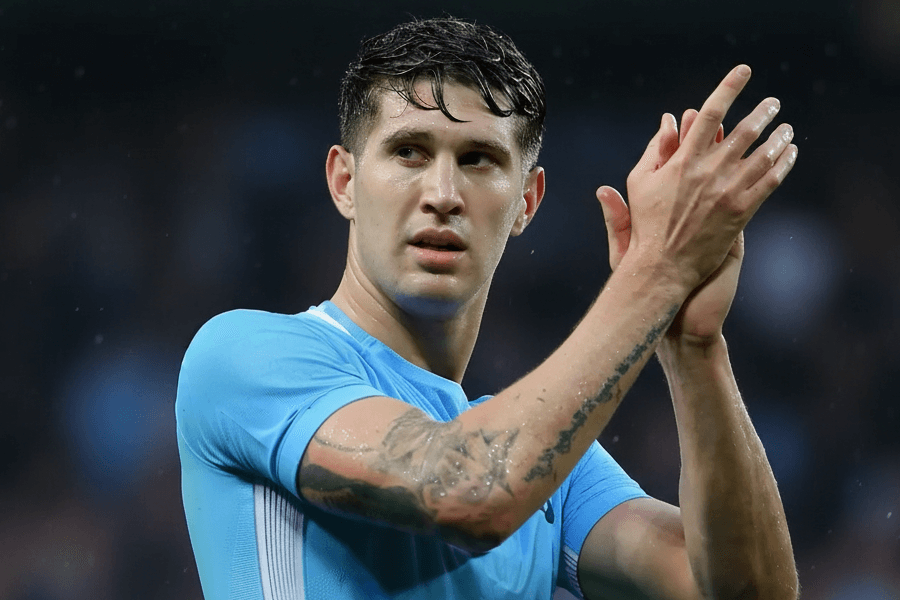 John Stones discutant avec ses coéquipiers sur le terrain.