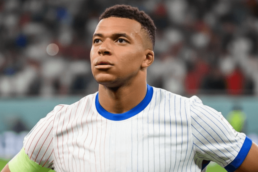 Mbappé levant les bras en signe de victoire après un but marqué avec le Real.