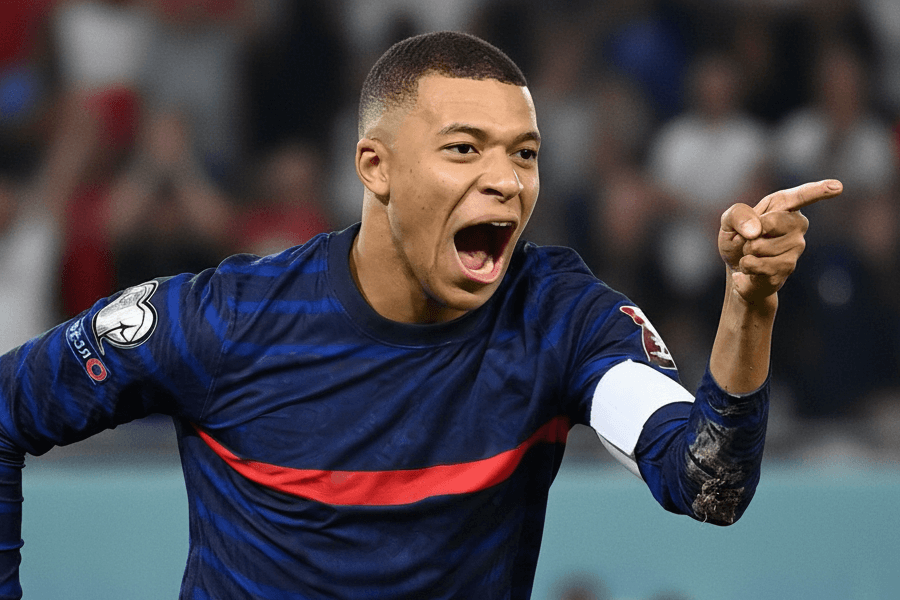 L'attaquant Kylian Mbappé soulevant les bras après sa performance exceptionnelle contre l'Olympiakos.