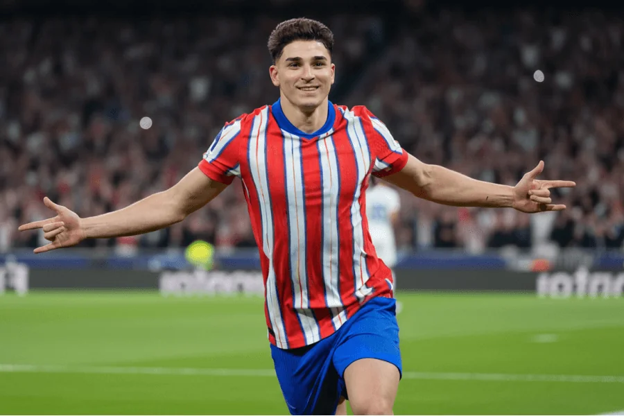 Julián Álvarez célébrant un but avec passion sous les couleurs de Manchester City, les bras levés vers les supporters.